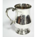 A Victorian baluster-shaped pint mug with foliate scroll handle, 5¼” high. London 1884, by F. J.