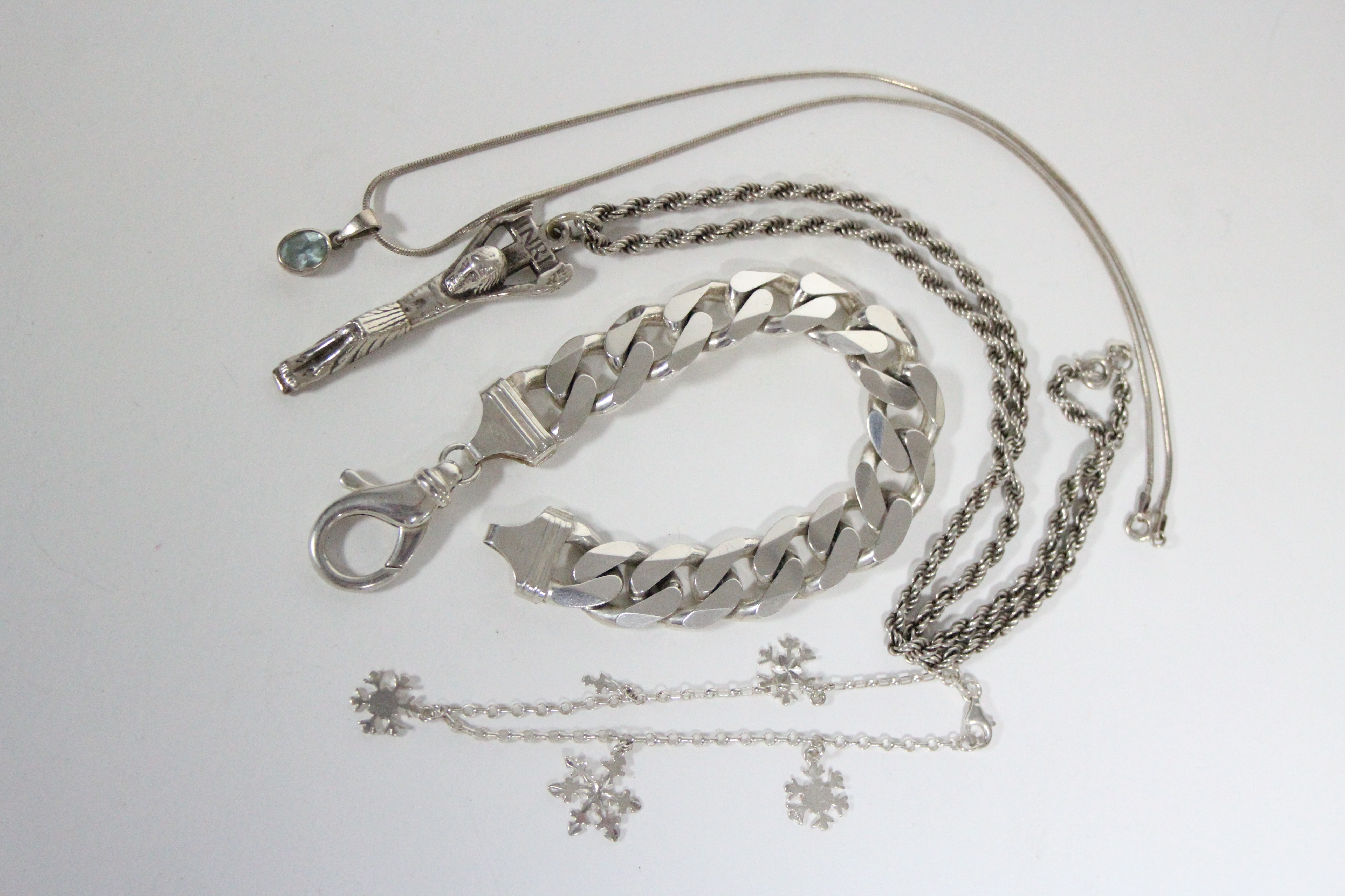 A gent’s silver bracelet of flat curb links, (2 oz); a silver crucifix pendant on rope-twist