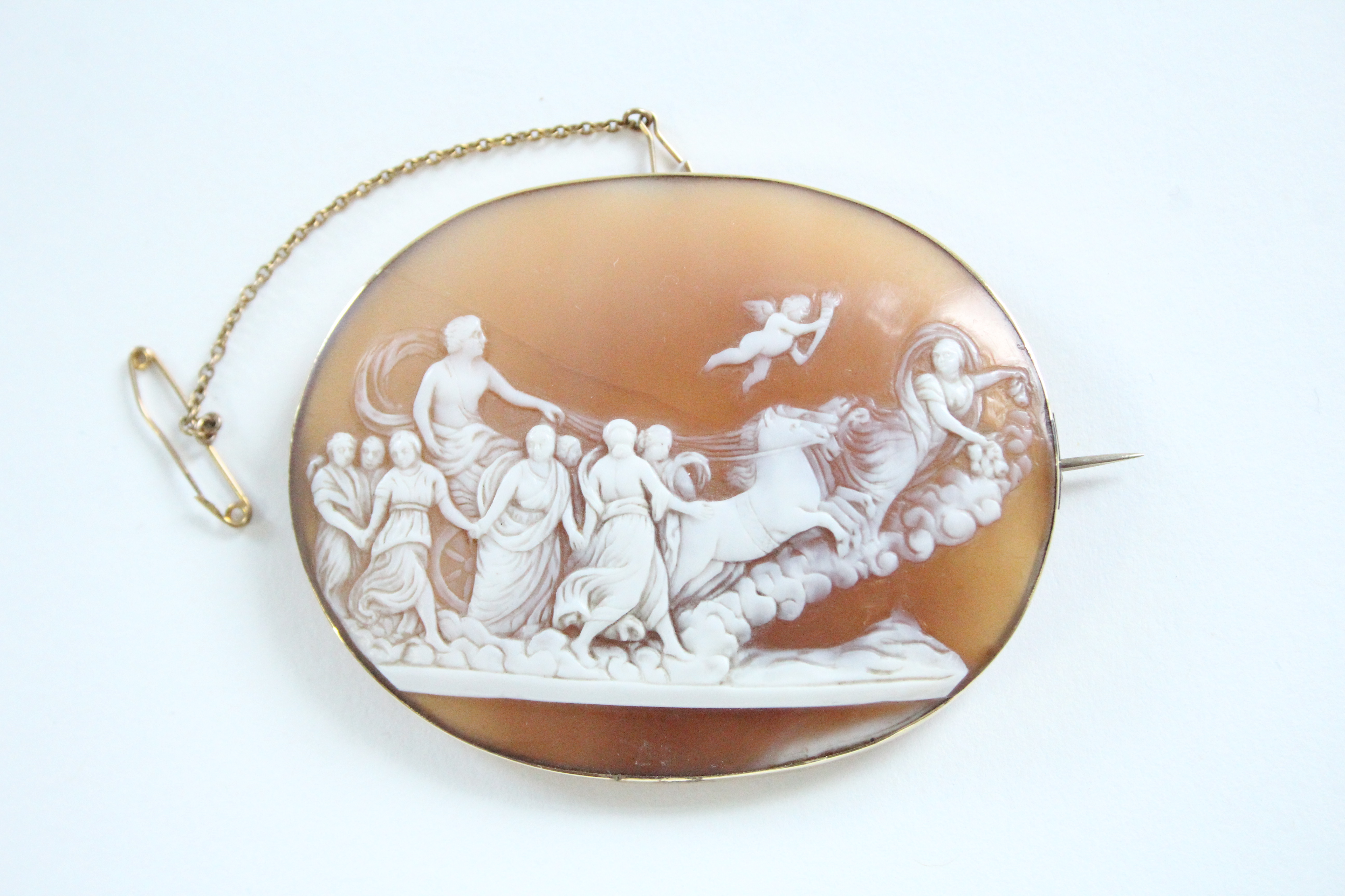 A 19th century carved shell oval cameo brooch depicting Apollo & Aurora, in gold mount; 2½” x 2”. (