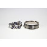 A titanium scarf ring; & a silver ring set spray of pale blue stones.