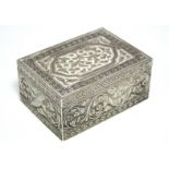 An Islamic silver rectangular box with hinged lid, all-over embossed with leaf-scrolls & foliate