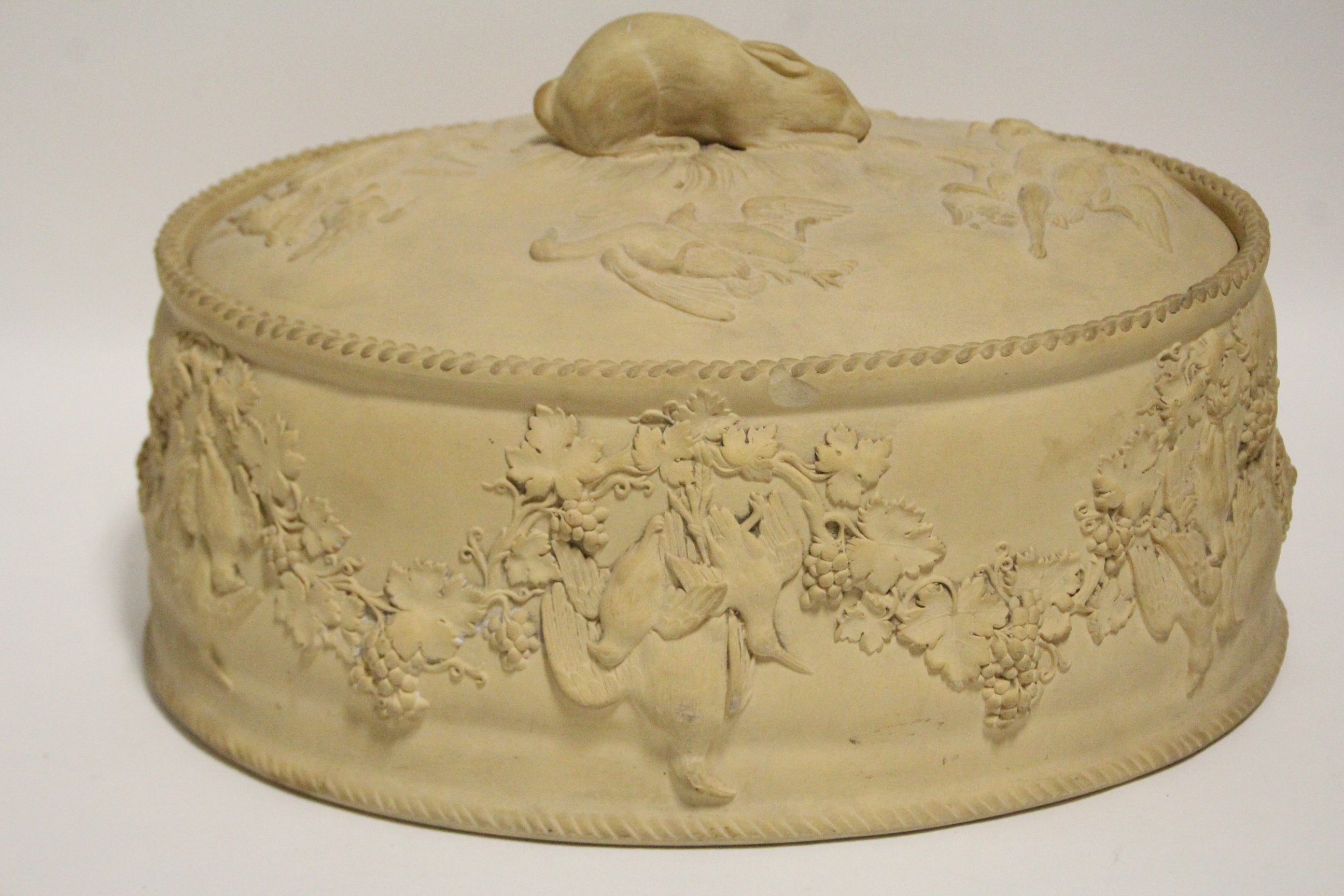 A 19th century Wedgwood caneware oval pie tureen with relief decoration of game birds &