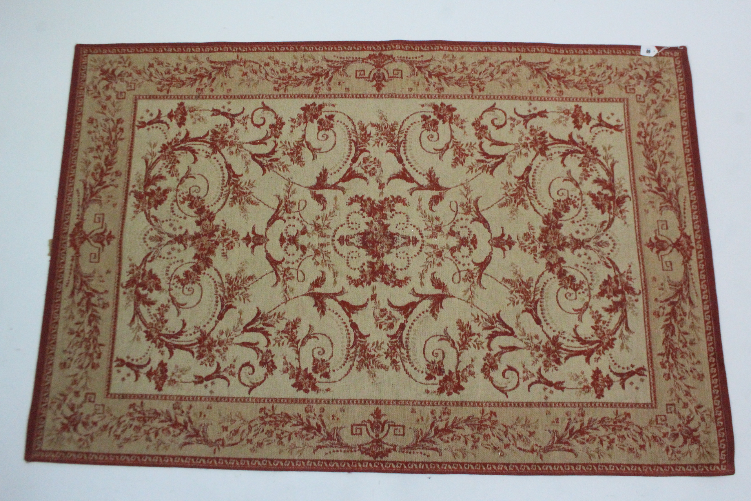 A Laura Ashley rug of cream ground & with all-over repeating crimson foliate design, 69¾” x 46”; & a