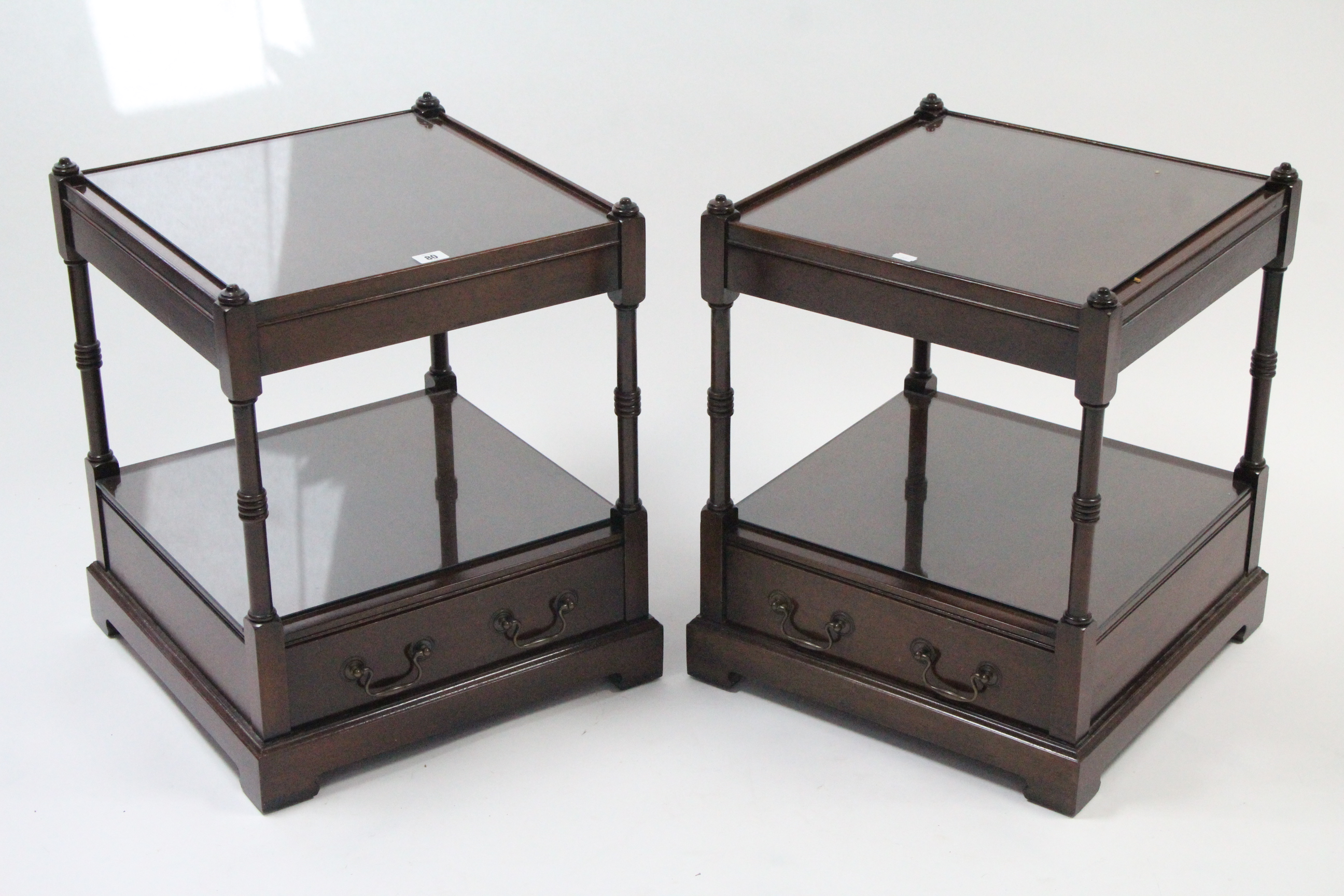 A pair of reproduction mahogany square two-tier occasional tables, each fitted drawer to the lower