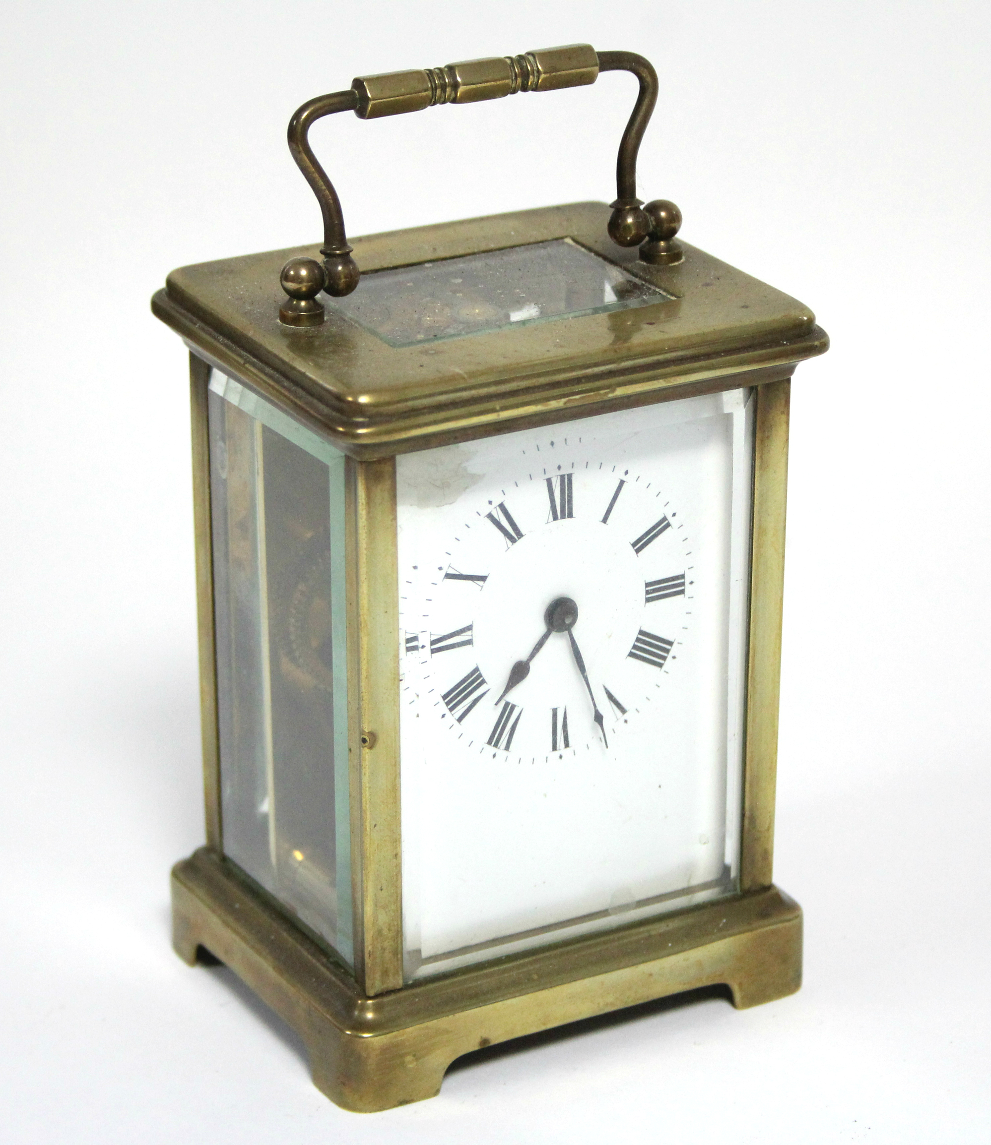 A brass cased carriage timepiece with black roman numerals to the white enamel dial; 4¼” high. (