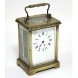 A brass cased carriage timepiece with black roman numerals to the white enamel dial; 4¼” high. (