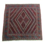 A tribal Kazak rug of blue, crimson & ivory ground with central geometric design within multiple