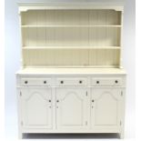 A cream painted pine dresser, the upper part fitted two open shelves & with panelled back, the