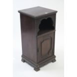 A late 19th/early 20th century mahogany bedside cabinet with open recess above a panel door, & on