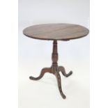 A late 18th century oak tripod table, the circular tilt top on turned column & three cabriole