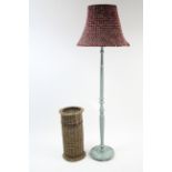 A pale blue painted wooden standard lamp with shade; & a woven-cane cylindrical umbrella stand.