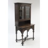 A 1930’s oak small bookcase the upper part with two adjustable shelves enclosed by pair of leaded