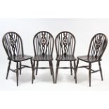 A set of four Windsor-style wheel-back dining chairs with hard seats, & on turned legs with