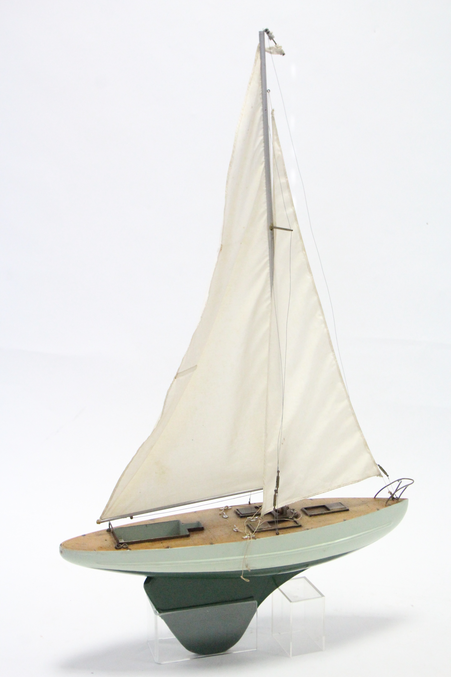 A painted wooden pond yacht with sails, 21” wide.