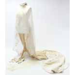 An early 20th century cream wedding outfit comprising a train, veil, headdress, pair of gloves, pair