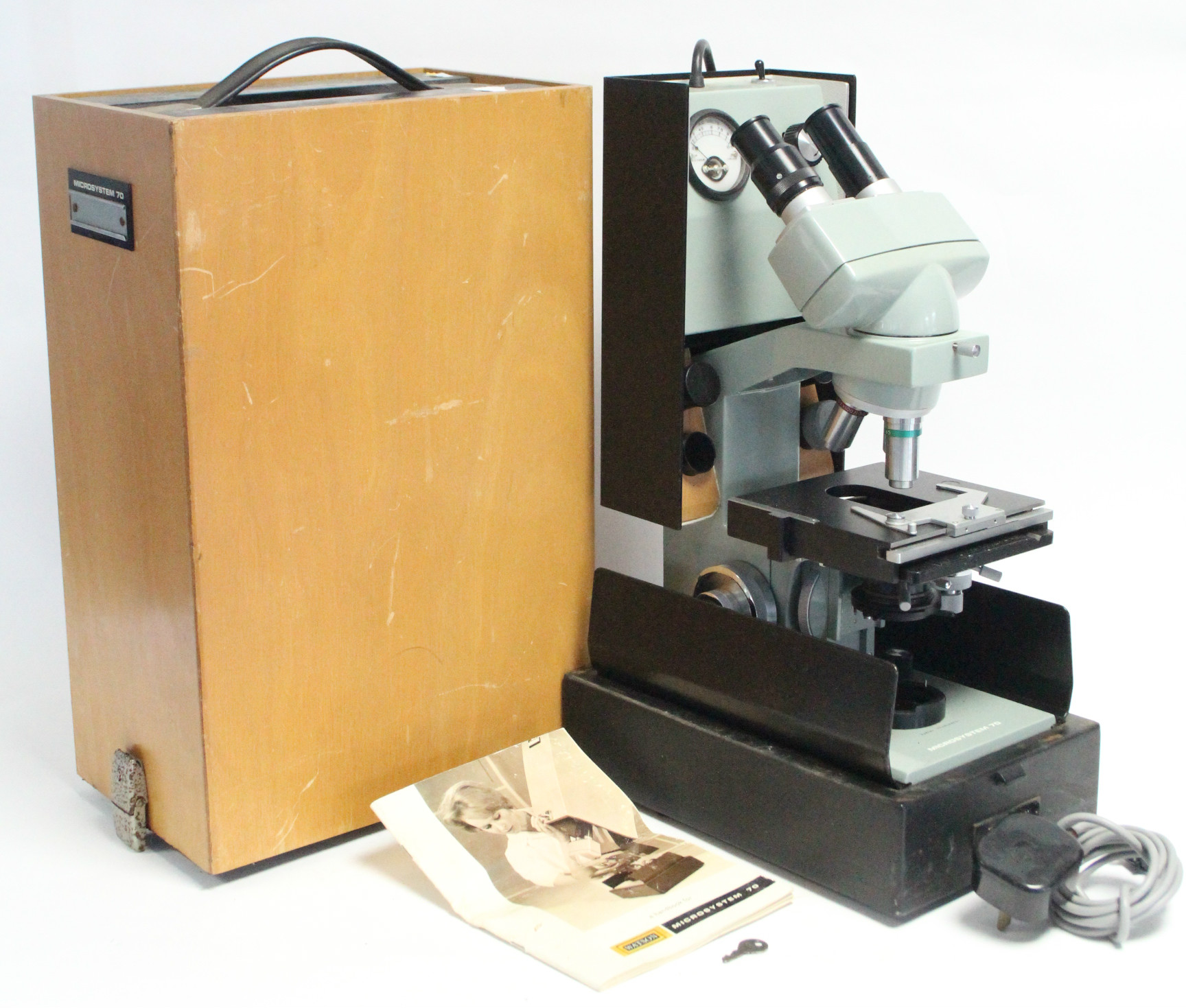 A Watson “Microsystem 70” electrically operated binocular microscope, with case.