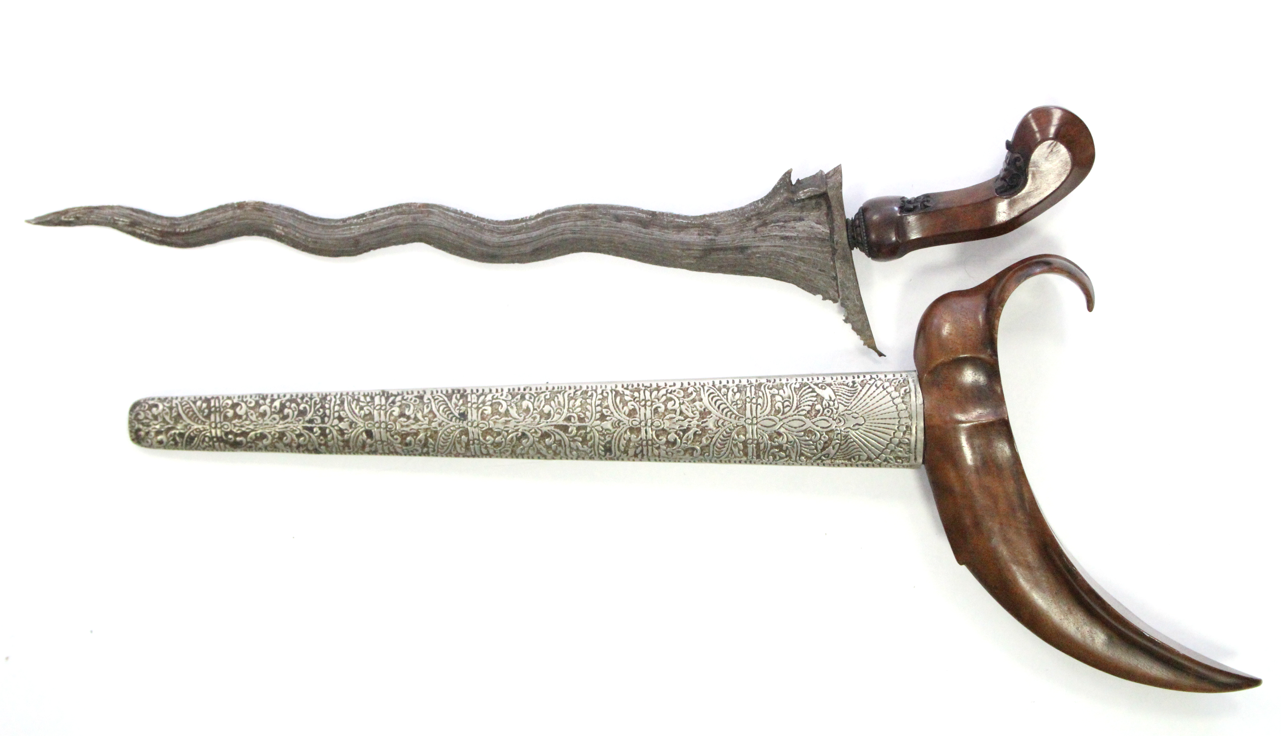 An eastern kriss with 13¼” long blade, with treen handle & engraved white-metal sheath.