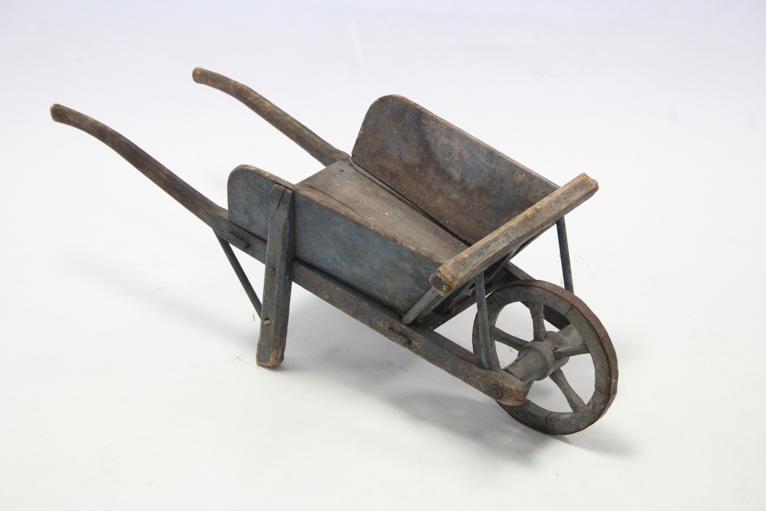 A painted wooden child’s wheelbarrow, 31¾” long, (w.a.f.).