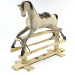 A DAPPLE GREY PAINTED WOODEN ROCKING HORSE ON TRESTLE BASE, 50” LONG X 50” HIGH.