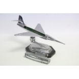 A chrome plated novelty table lighter in the form of an aeroplane mounted on ebonised plinth base,