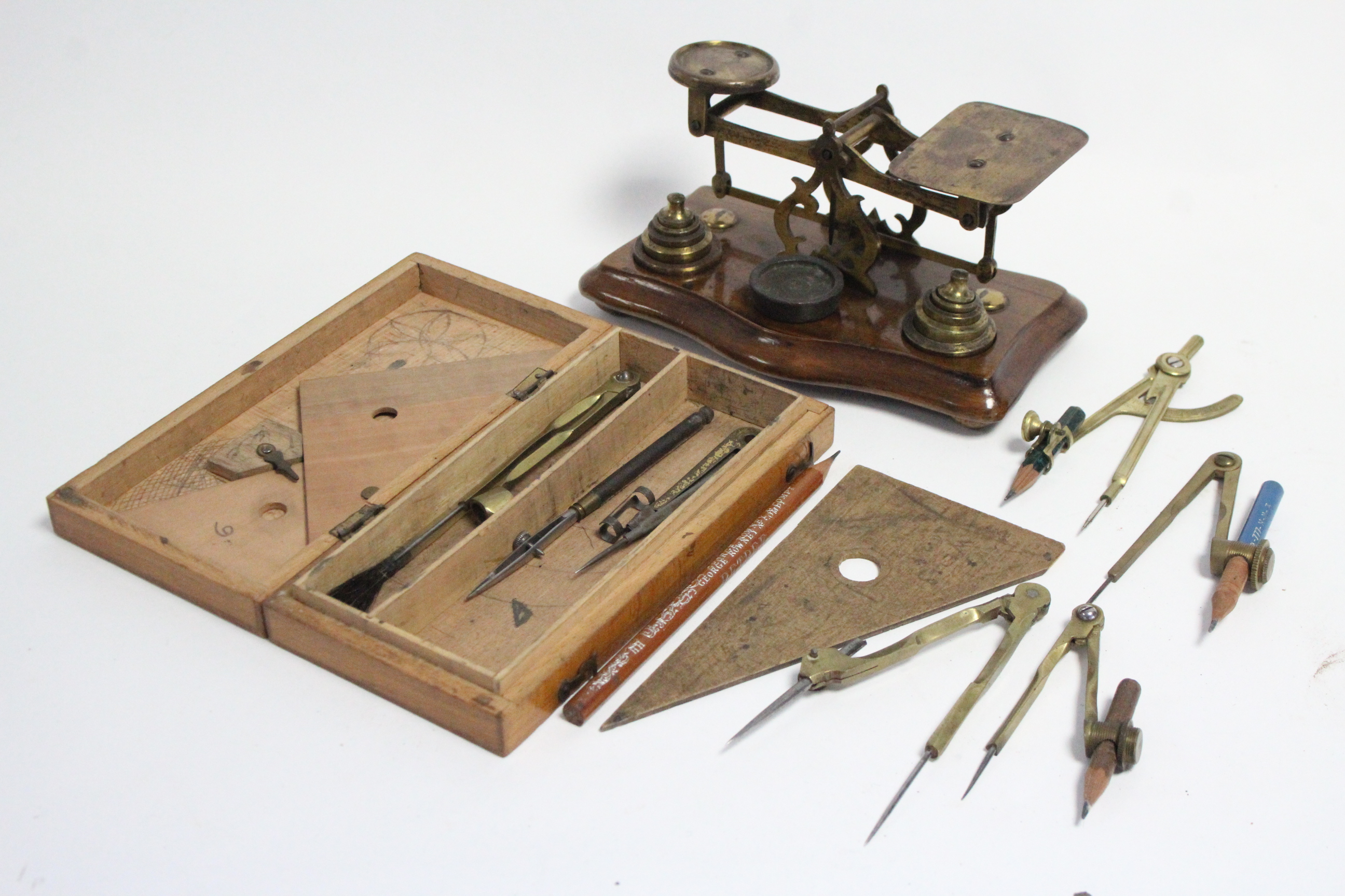 An early 20th century brass letter scale mounted on walnut serpentine-front platform base, & with