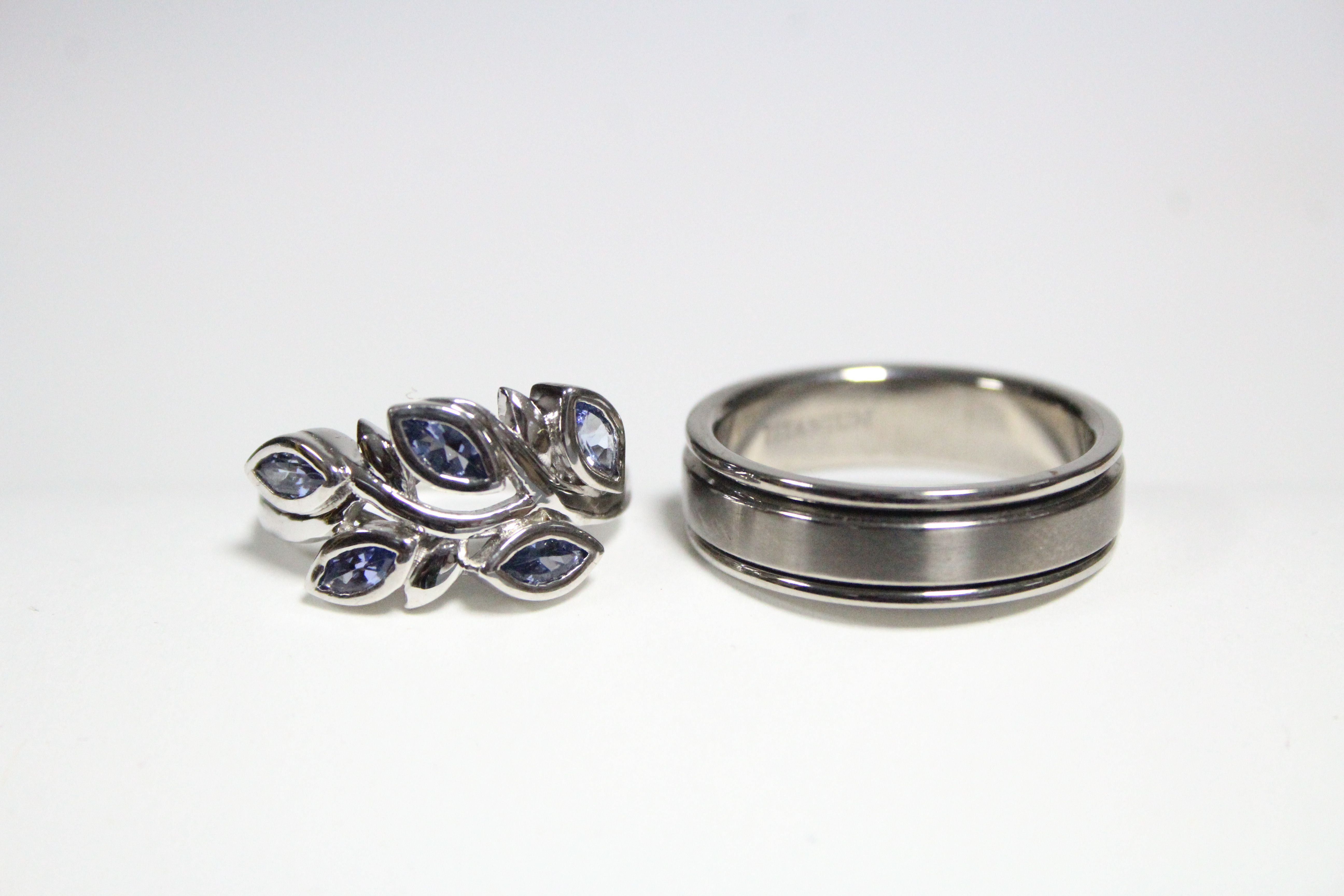 A titanium scarf ring; & a silver ring set spray of pale blue stones.