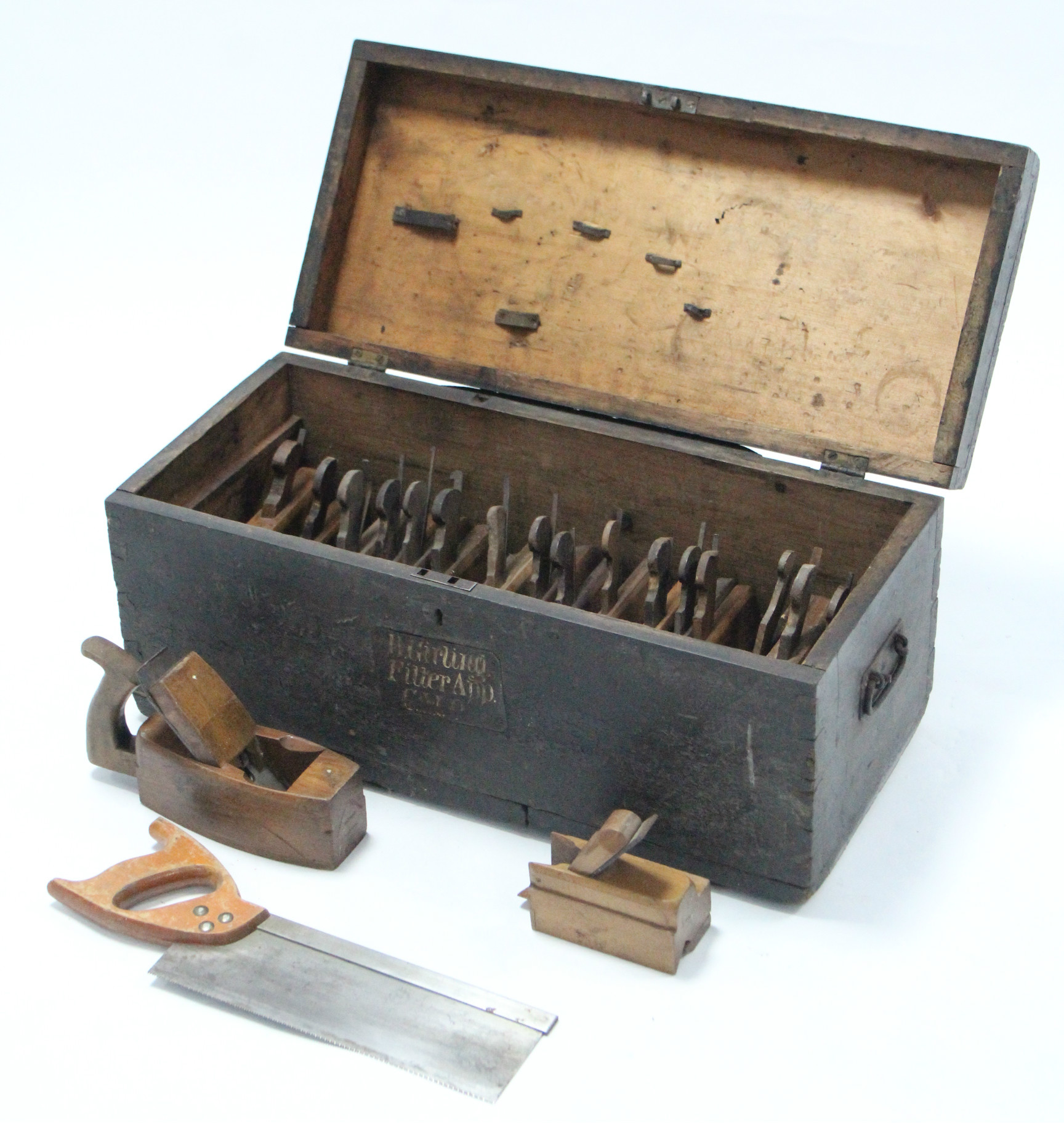 A black painted deal tool chest, 25½” wide, containing various carpenter’s tools.