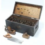 A black painted deal tool chest, 25½” wide, containing various carpenter’s tools.