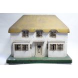 An early-mid 20th century Tri-ang painted wooden cottage-style two-storey doll’s house, with opening