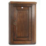A 19th century small oak hanging corner cupboard fitted two shelves enclosed by panel door, 26" wide