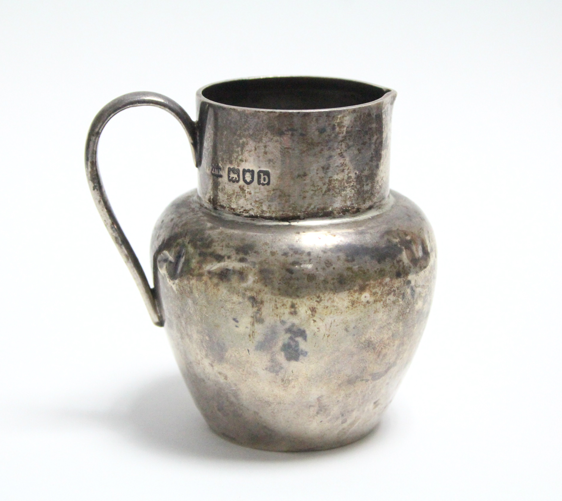 A late Victorian silver globular cream jug, 3" high, London 1897.