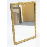 A large gilt frame rectangular wall mirror with raised foliate border, 39½” x 27½”.