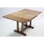 A mid-20th century oak draw-leaf dining table on pair of square tapered end supports to either end