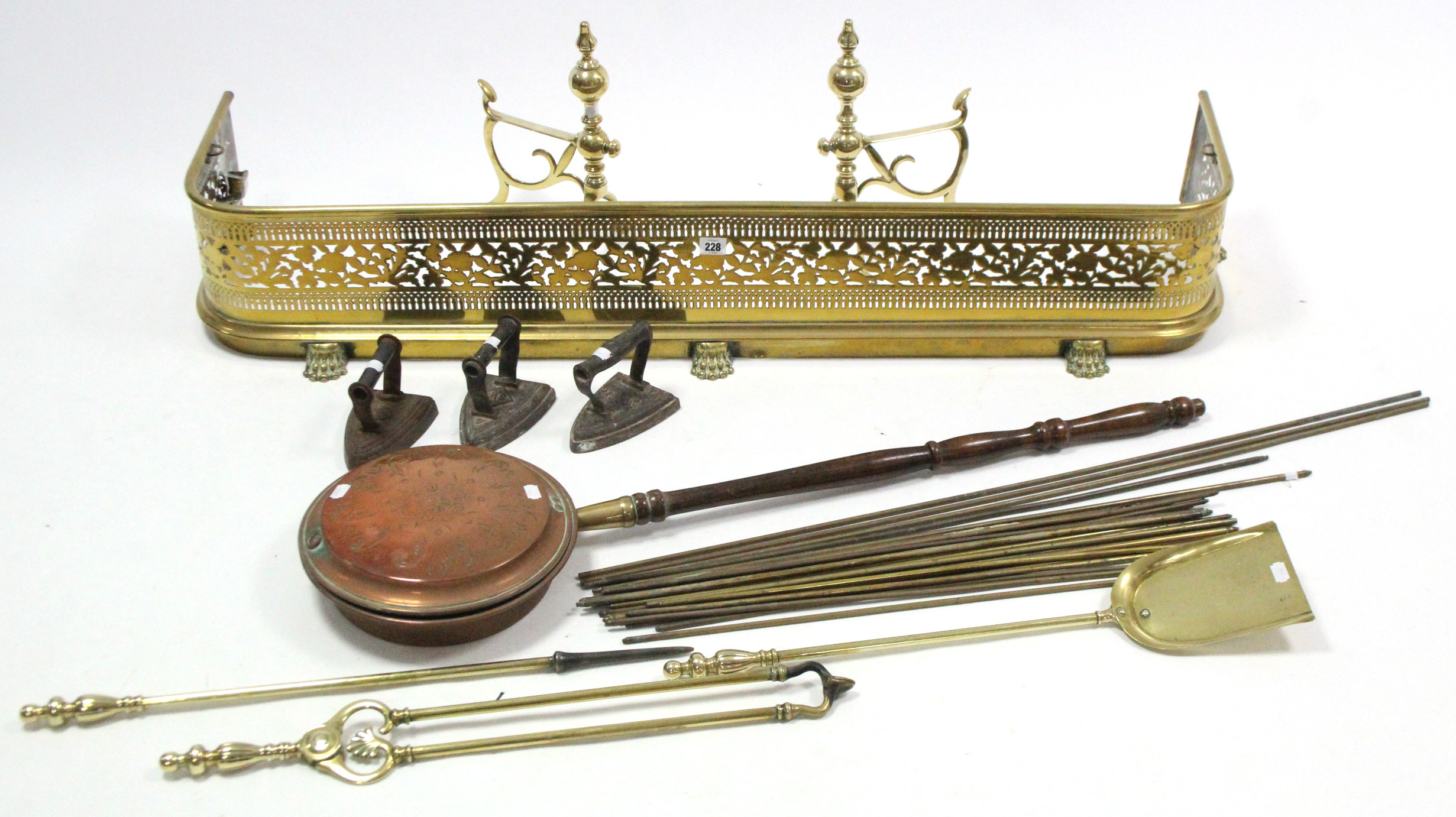 A 19th century brass fender with pierced frieze, 48½” long; a 19th century copper engraved warming