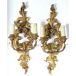 A pair of rococo-style giltwood twin-branch wall sconces, 20¾” high; & a pair of continental-style