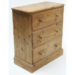 A pine chest fitted three long drawers with turned knob handles; & on plinth base, 30¾” wide.