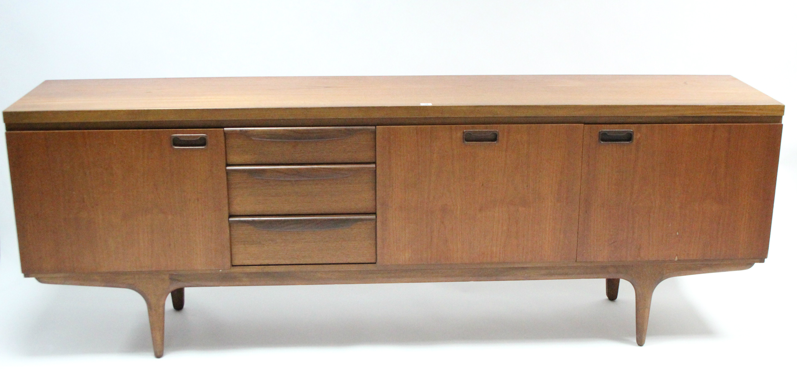 A mid-20th century large teak sideboard fitted with an arrangement of drawers & cupboards, & on