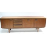 A mid-20th century large teak sideboard fitted with an arrangement of drawers & cupboards, & on