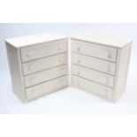 A pair of white painted wood chests each fitted four long drawers with turned knob handles, 30” wide