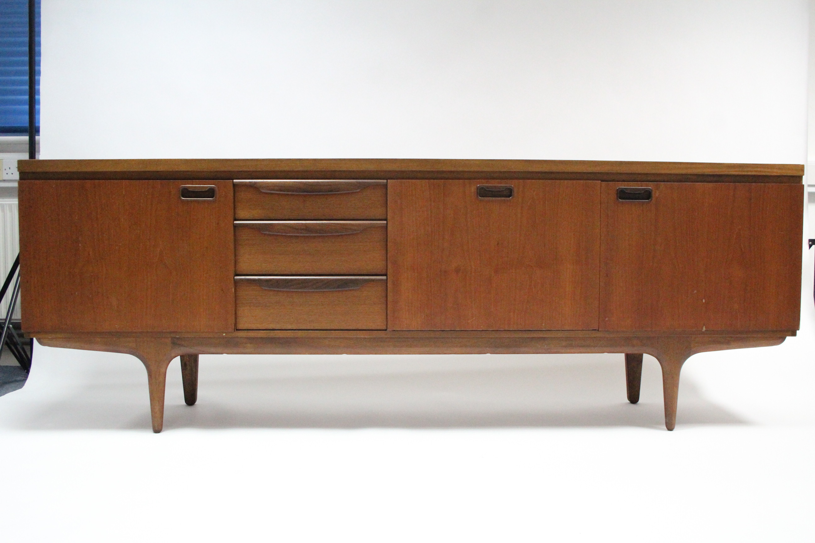 A mid-20th century large teak sideboard fitted with an arrangement of drawers & cupboards, & on - Image 5 of 7