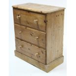 A pine chest fitted three long drawers with turned knob handles; & on plinth base, 30¾” wide.