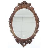 A 19th century-style carved wood frame oval wall mirror inset bevelled plate, 43” x 27”.