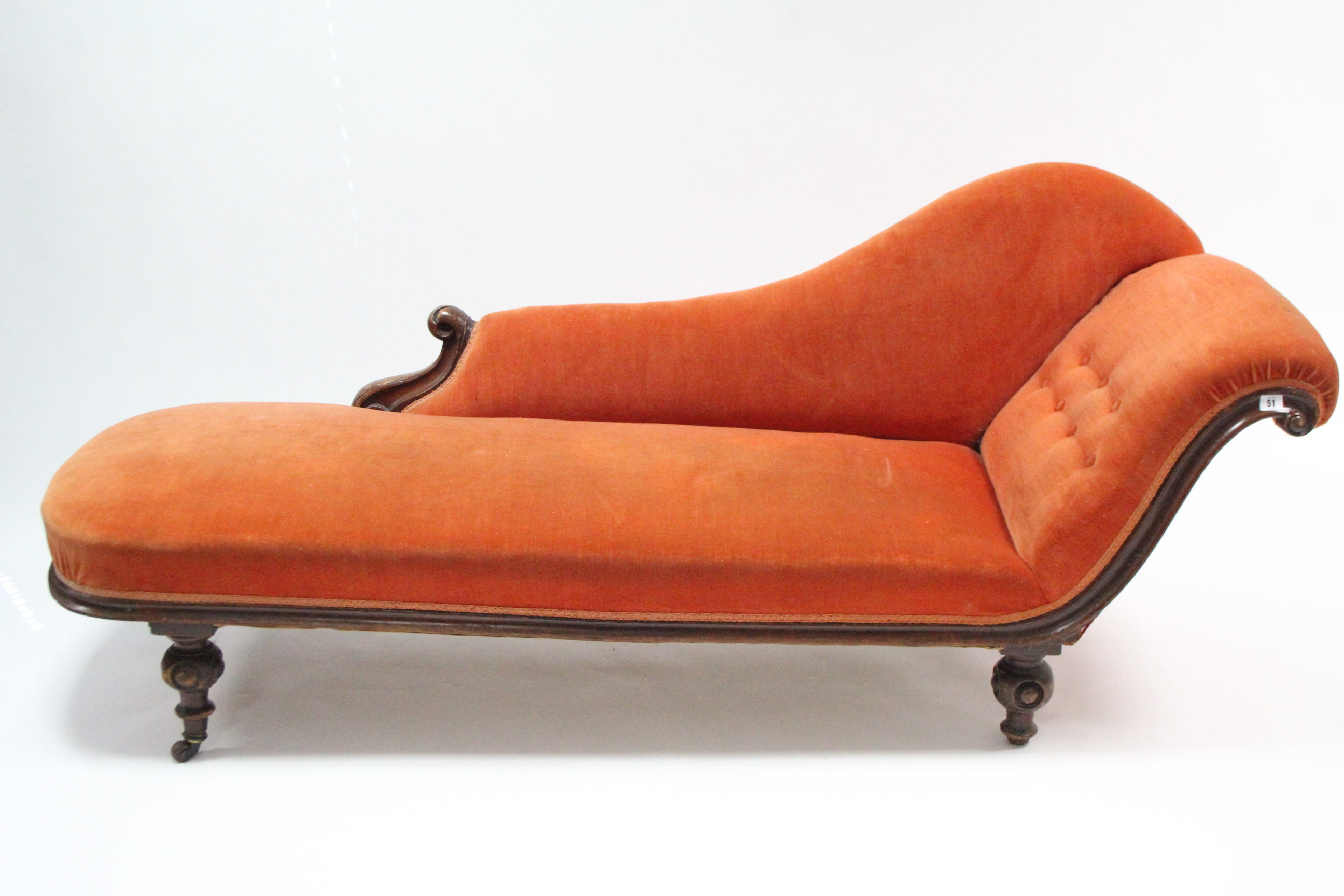 A late Victorian carved walnut frame chaise longue with buttoned scroll end & sprung seat