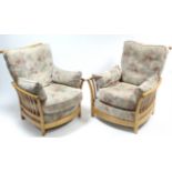 A pair of Ercol light elm frame armchairs with loose cushions to the seats & backs, & on short round