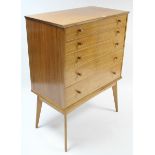 A mid-20th century teak chest by Alfred Cox of London, fitted five long graduated drawers with