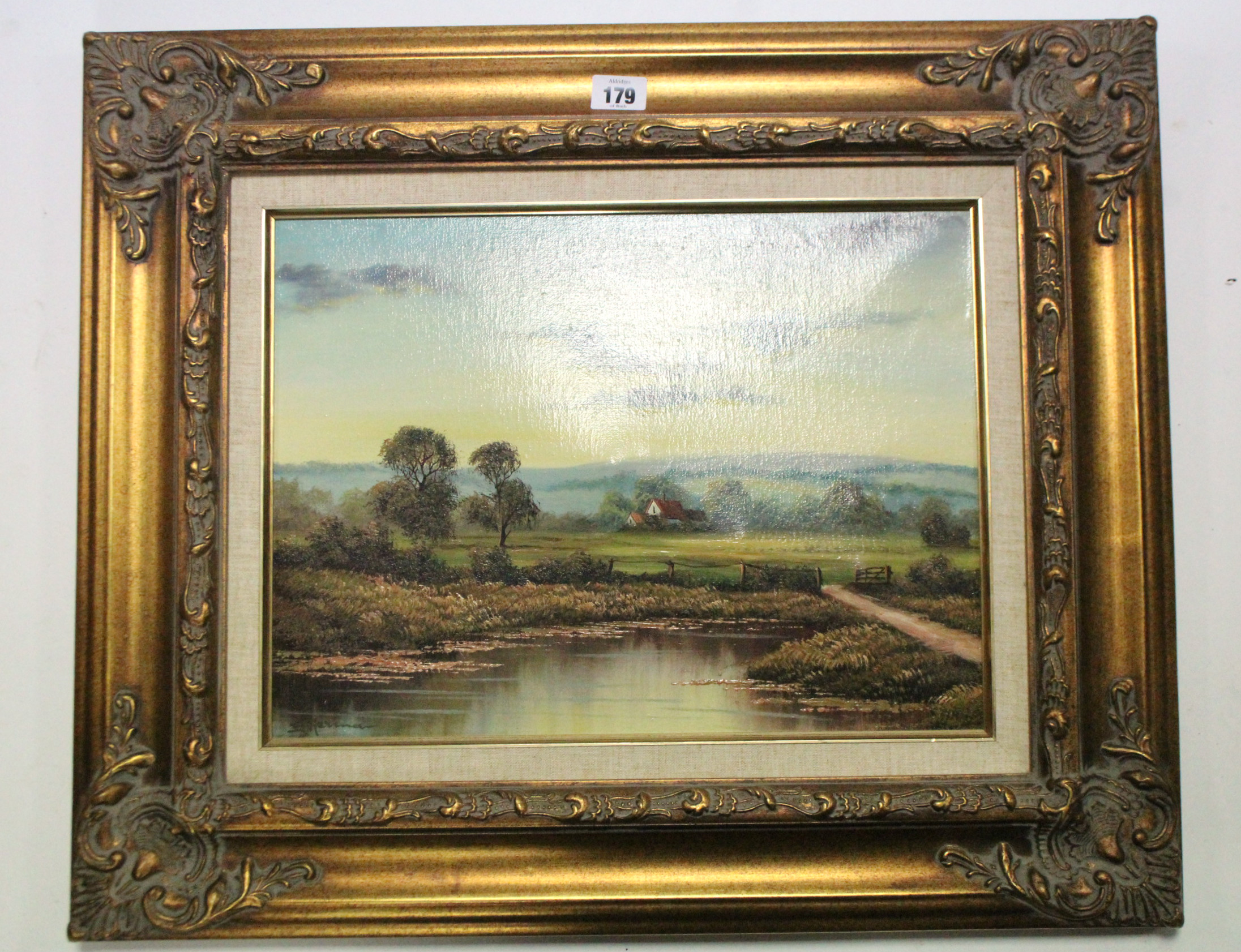 A modern oil painting on canvas of a river scene with farm building to the background, signed J.