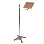 An Edwardian brass & oak adjustable reading stand on cast-iron base with four shaped legs.