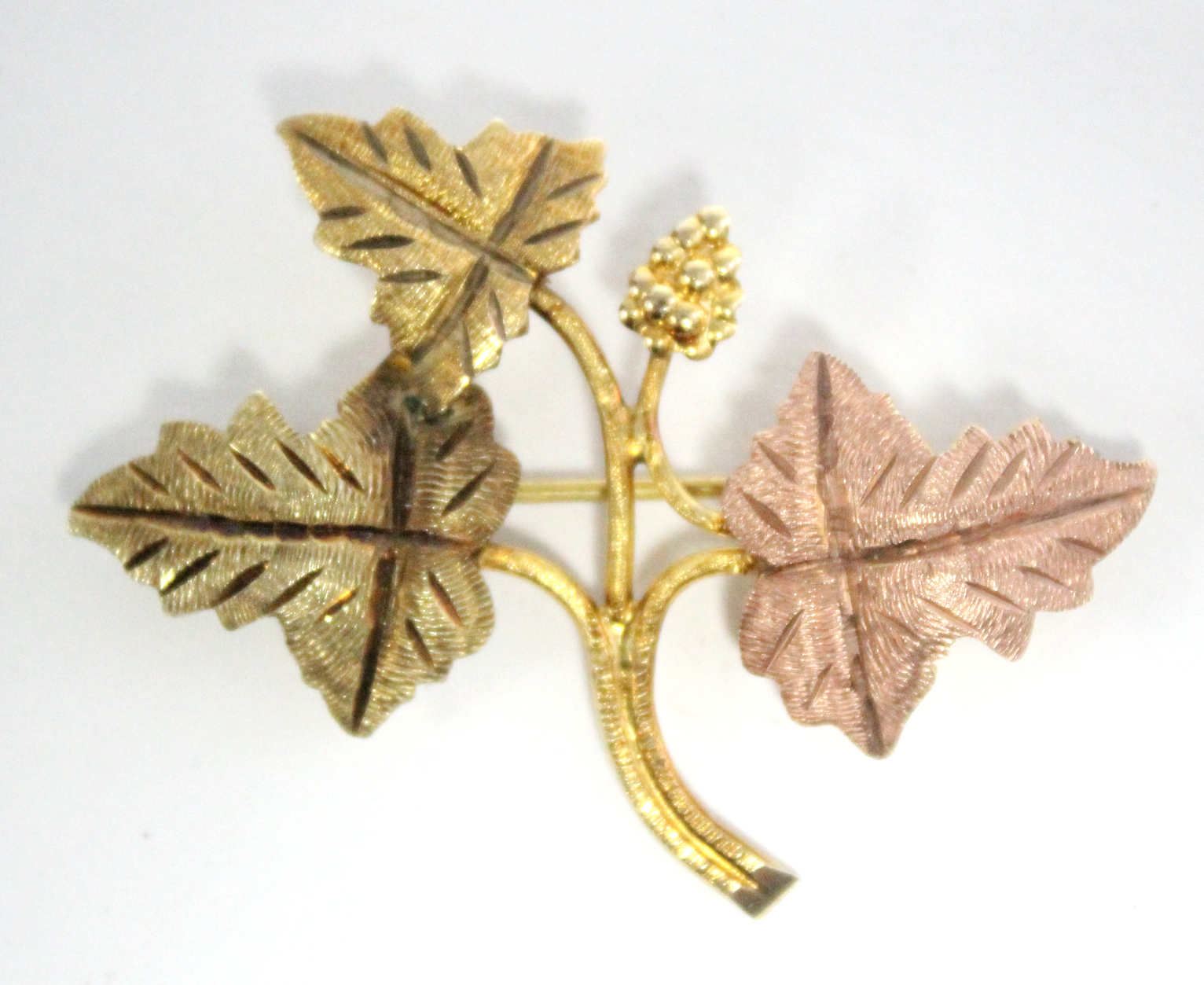 An un-marked three-colour metal leaf spray brooch.