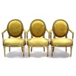 A set of three Louis XVI-style carved giltwood open armchairs with oval padded backs & seats