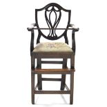 A 19th century mahogany Hepplewhite-style child’s high chair, with pierced splat to the shield-